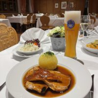 Roast pork with dark beer sauce, coleslaw and potato dumplings