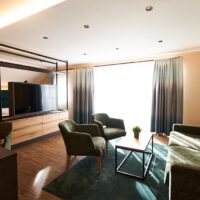 Juniorsuite mit Sitzgelegenheit, Fenster mit Tageslicht und Vorhängen zum verdunkeln in Ismaning